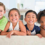 A group of children smile after receiving a fluoride treatment at the dentist in Pharr, TX