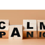 Wooden blocks turning from the word PANIC to CALM