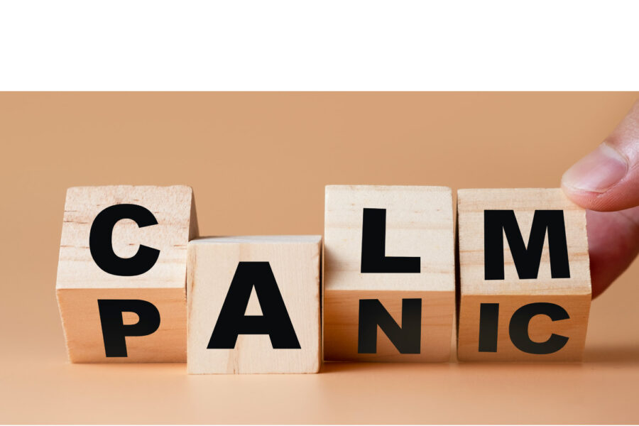 Wooden blocks turning from the word PANIC to CALM
